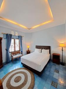 日惹Kutus Kutus Clemmie Huis的卧室配有一张白色大床和地毯。