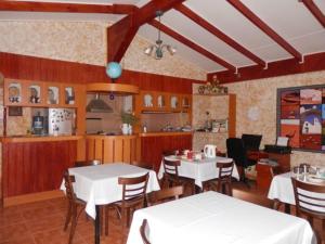 圣佩德罗·德·阿塔卡马索洛旅馆的一间带白色桌椅的餐厅和一间厨房