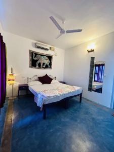 科钦Chameleon Beach Resort, Cherai的一间卧室配有一张床和吊扇