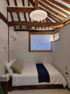 顺天市Premium Hanok Villa Namo On的一间带一张床铺的卧室,位于带天花板的房间内