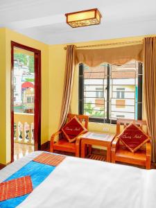 萨帕Cherry Hotel的一间卧室配有一张床、两把椅子和一个窗户