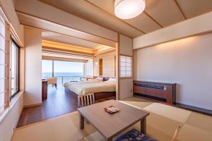 东伊豆町恩娜彤日东海大厦酒店的卧室配有一张床和一张桌子