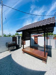 麻坡NS Vacation Home Muar with Kids Friendly Pool的一个带屋顶的小型木制凉亭