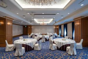 京都日航国际酒店的宴会厅配有白色的桌椅和吊灯。
