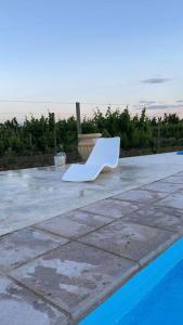 图努扬Casa full equipada (villa seca)的坐在泳池旁的庭院上的白色椅子