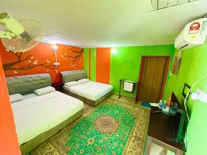 TumpatDGeting Beach Resort的一间设有两张床的客房,拥有绿色和橙色的墙壁