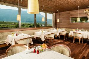 阿皮亚诺苏拉斯特拉达格尔兰纳霍夫酒店的餐厅设有白色的桌椅和窗户。