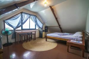 爱妮岛Bangka Hostels的一间卧室配有一张床、一张桌子和一个窗户。