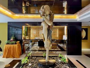 芭堤雅市中心Nova Gold Hotel Pattaya的坐在桌子上的女人的雕像