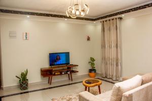 坎帕拉BRB Homes - Spacious 1 Bedroom Apatment - Bukoto, Kampala的客厅配有沙发和墙上的电视