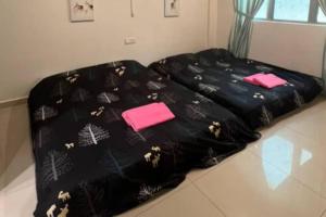卢穆特D'Sea Marina Island Resort by Manhattan Group的一张黑色床,上面有粉红色的毛巾
