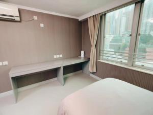 香港皇后超級管家的一间卧室设有长凳和大窗户