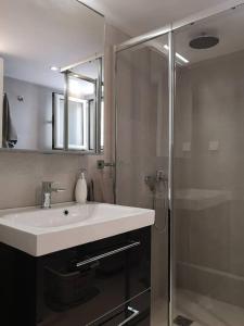 瓦里Varkiza Sea View Apartment - Free Parking的一间带水槽和淋浴的浴室