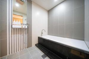 NajuHotel Core的设有带浴缸和淋浴的浴室。