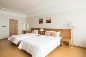 NajuLake 45 Hotel的酒店客房,配有两张带白色床单的床