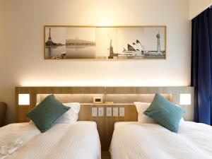 福冈博多总统大酒店的酒店客房设有两张床,墙上挂着一张照片。