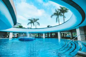 三亚三亚海棠湾民生威斯汀度假酒店(享免税店9.5折)的一座建筑中间的游泳池,带喷泉