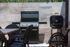 麦地那西多尼亚Casa Caramelo的庭院设有烧烤架和桌椅。