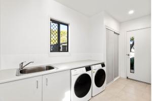 马莱尼Tranquil Getaways On Obi Maleny的白色的厨房配有水槽和洗衣机
