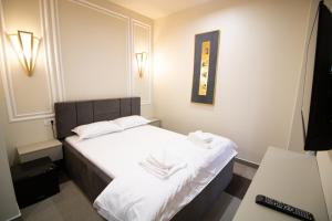 布泽乌HOTEL GLAMOUR IMPERIAL的酒店客房的床铺配有白色的床单和毛巾。
