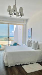 沃利迪耶Maison Simonetta的卧室设有一张大白色的床和大窗户