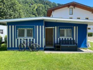 阿绍***** Camping Aufenfeld - Sonnenglückhütte的停在蓝色棚屋前的自行车
