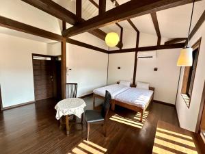大津Inase Otsu Machiya Bed and Breakfast的一间卧室配有一张床和一张桌子