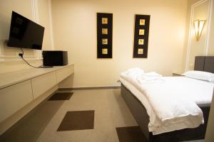 布泽乌HOTEL GLAMOUR IMPERIAL的客房设有一张床和一台平面电视。