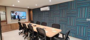斋浦尔Indie Stays Jaipur的一间会议室,配有桌椅和屏幕