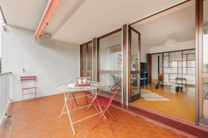比亚里茨Sixties 64 2 bedrooms apartment with a balcony and parking in Biarritz的一间设有桌子和玻璃墙的用餐室