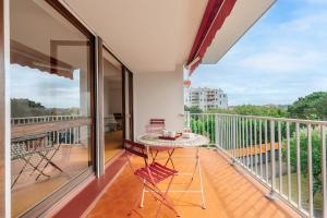 比亚里茨Sixties 64 2 bedrooms apartment with a balcony and parking in Biarritz的设有一个配有桌子并享有美景的阳台。
