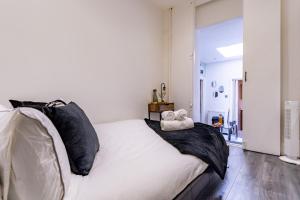伦敦Prime Location - Cosy Apartment near Emirates Stadium的一间卧室配有一张带黑白枕头的床
