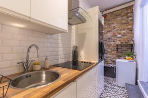 伦敦Prime Location - Cosy Apartment near Emirates Stadium的厨房设有水槽和砖墙