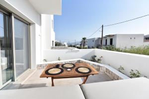 阿达玛斯Anais Milos Suites的屋顶上带桌子的小阳台