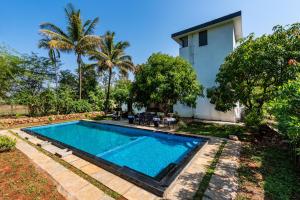 浦那SaffronStays Lakeview Nivara - Farm Stay Villa with Private Pool near Pune的一座房子的院子内的游泳池