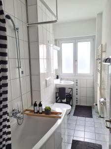 苏黎世2 BR - Kingsize Bett - Garten - Parken - Küche的白色的浴室设有浴缸和水槽。
