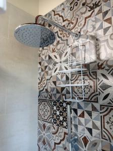 卢卡Monolocale Lucca PellegriniLittleHouse的一间带淋浴的浴室和瓷砖墙