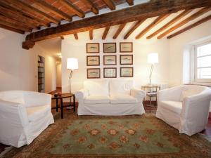 Rocca GrimaldaLuxurious Apartment in Rocca Grimalda with Garden的客厅配有两把白色椅子和地毯
