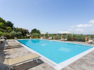 渥尔特拉Lavish Holiday Home in Volterra with Pool的周围设有大型游泳池,配有躺椅