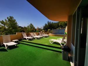 巴尔奇克HOTEL PARIS Spa area的一个带椅子的庭院和一个带绿草的草坪