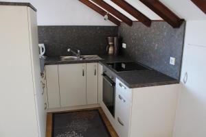 ZwiefaltenFerienwohnung Fernsicht的小厨房配有白色橱柜和水槽