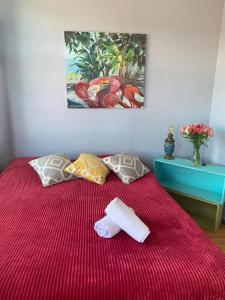 第比利斯Hostel ERA的一张红色的床,带两条毛巾和墙上的画作