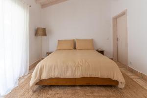 塞卡尔Vale da Cassiopeia的一间白色卧室,房间内设有一张大床