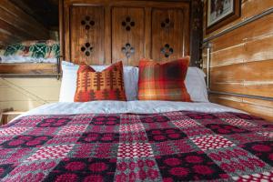 GoodwickDennis的一张带 ⁇ 子毯子和枕头的床