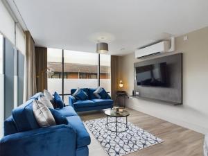 贝尔法斯特Bradbury Apartment on Lisburn Road by Lesley的客厅配有2张蓝色沙发和电视