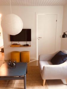 维比Villa med private værelser og delt køkken/badrum, centralt Viby sj的带沙发和电视的客厅
