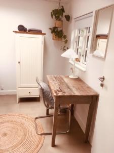 维比Villa med private værelser og delt køkken/badrum, centralt Viby sj的一张木桌、椅子和灯