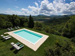 阿夸拉尼亚Pretty Holiday Home in Acqualagna with Swimming Pool的草地上游泳池的顶部景色