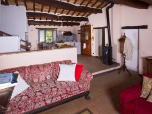 阿夸拉尼亚Pretty Holiday Home in Acqualagna with Swimming Pool的一间带红色沙发的客厅和一间厨房