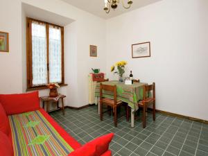 斯特雷萨Enticing Apartment in Stresa with Balcony Lake Views的客厅配有桌子和红色沙发